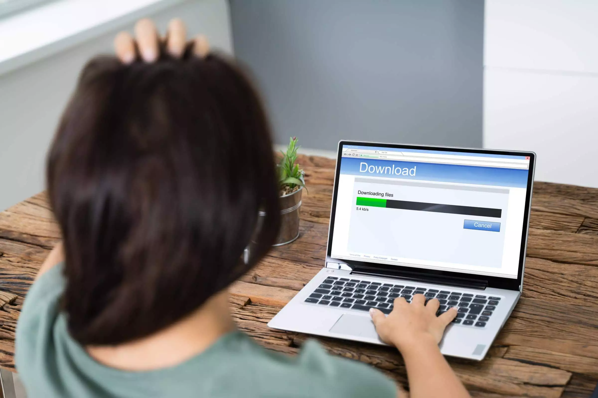 Stressed Woman Looking At Slow Download Speed On Laptop Screen